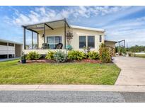 Charming home featuring a covered porch and a well-manicured lawn with lush landscaping at 4119 13Th E St, Ellenton, FL 34222