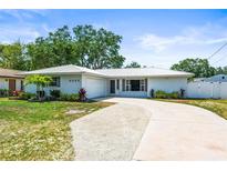 Charming single-story home featuring a metal roof, landscaped yard, and a driveway that compliments the curb appeal at 4425 Parnell Dr, Sarasota, FL 34232