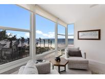Bright living room features floor-to-ceiling windows with stunning beach and ocean views at 5200 Gulf Dr # 408, Holmes Beach, FL 34217