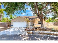 Charming one-story home featuring an attached garage, mature landscaping, and a welcoming front porch at 5623 Wilde Oak Way, Sarasota, FL 34232