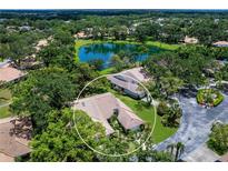 Aerial view of a beautiful home with a private backyard overlooking a serene lake surrounded by lush greenery at 5729 Garden Lakes Palm, Bradenton, FL 34203