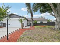 Charming single-story home features a well-maintained lawn, palm trees, and an attached two-car garage at 612 65Th W Ave, Bradenton, FL 34207
