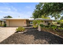 Charming single-story home featuring a well-maintained front yard, brick driveway, and attached two car garage at 6512 Bowline Dr, Sarasota, FL 34231