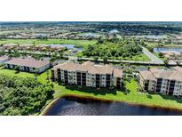 Scenic aerial view of condo building with golf course and lakes in a well-manicured community at 6519 Grand Estuary Trl # 107, Bradenton, FL 34212