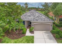 Charming home featuring a tile roof, two-car garage, well-maintained landscaping, and a welcoming walkway at 661 Foggy Morn Ln, Bradenton, FL 34212