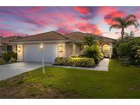 Charming single-story home with a tile roof, well-manicured lawn, and lush tropical landscaping at 6764 Hickory Hammock Cir, Bradenton, FL 34202