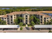 Beautiful condo community with a tile roof, lush landscaping, and covered parking at 7005 River Hammock Dr # 206, Bradenton, FL 34212