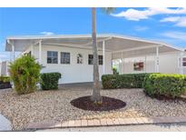 Charming single-story home showcasing a well-maintained exterior with a covered parking area and landscaped front yard at 720 S Green Cir, Venice, FL 34285