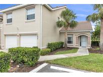 Inviting home exterior showcasing a well-manicured lawn, a two-car garage, and palm trees at 7637 Sweetbay Cir, Bradenton, FL 34203