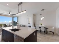 Bright kitchen with a large island, stainless steel appliances, and balcony views at 1155 N Gulfstream Ave # 406, Sarasota, FL 34236