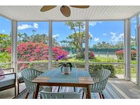 The screened lanai has a table and chairs, ceiling fan and a colorful view of the surrounding landscaping and tennis courts at 1226 Siesta Bayside Dr # 1226C, Sarasota, FL 34242