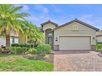 Charming single-story home with a brick driveway, lush landscaping and two-car garage at 148 Wandering Wetlands Cir, Bradenton, FL 34212