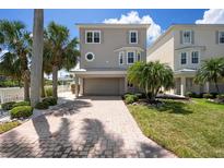 Charming two-story home with a brick driveway and well-manicured landscaping, creating a welcoming curb appeal at 215 65Th St, Holmes Beach, FL 34217