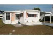 Charming mobile home with white siding, awning, and a covered carport perfect for enjoying the Florida sunshine at 5119 Glen Echo Ave, Sarasota, FL 34234