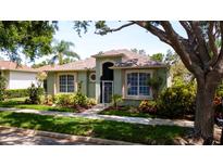 Inviting front yard with mature trees, lush landscaping, and well-maintained lawn at 553 Meadow Sweet Cir, Osprey, FL 34229