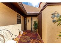 Inviting home entry with decorative rug and welcome sign, complemented by neutral-toned stucco and well-maintained exterior at 5709 13Th W Ave, Bradenton, FL 34209
