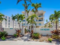 Beautiful condo building entrance with lush landscaping and striking architectural details at 6512 Midnight Pass Rd # 303, Sarasota, FL 34242