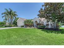 Charming single-story home featuring a well-manicured lawn and mature tropical landscaping at 6539 Flycatcher Ln, Lakewood Ranch, FL 34202