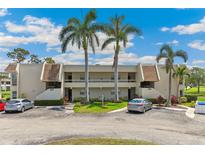 Charming two-story condo with a well-manicured lawn, mature palms, and assigned parking spaces at 7193 W Country Club N Dr # 137, Sarasota, FL 34243
