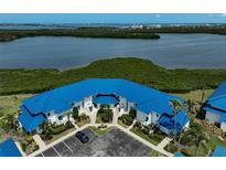 Waterfront condo complex with blue roof and lush landscaping overlooking bay at 939 Sandpiper Cir, Bradenton, FL 34209