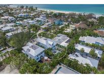 Stunning aerial view of a coastal home featuring a lush tropical landscape near a beautiful beach at 120 White Ave, Anna Maria, FL 34216