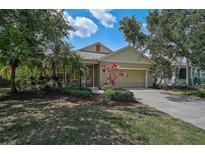 Charming single-story home featuring a manicured lawn, mature trees, and an attached two-car garage at 12149 Forest Park Cir, Bradenton, FL 34211