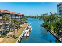 Beautiful condo exterior with waterfront access, boats, and tropical landscaping at 1350 N Portofino Dr # 208, Sarasota, FL 34242