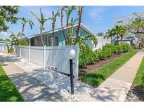 Charming home with a white picket fence, lush landscaping, and a well-maintained sidewalk at 170 Roosevelt Dr # 2, Sarasota, FL 34236