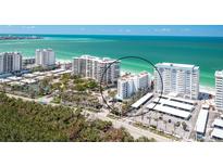 Panoramic aerial view of beachfront condos with sparkling turquoise waters and lush landscaping at 1770 Benjamin Franklin Dr # 407, Sarasota, FL 34236