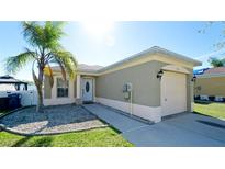 Charming single-story home featuring stucco siding, a one-car garage, a well-maintained lawn and mature landscaping at 2330 28Th E Ave, Palmetto, FL 34221