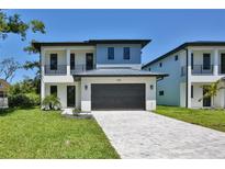 Two-story home with modern design, featuring a large garage, driveway, and landscaped front yard at 2335 Oak Ter, Sarasota, FL 34231