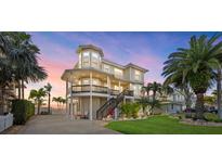 Beautiful elevated coastal home with a large front porch and well-manicured lawn, perfect for waterfront living at 2438 Baywood W Dr, Dunedin, FL 34698