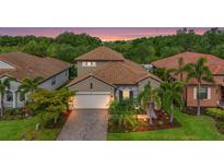 Charming single-Gathering home with a well-manicured lawn, paver driveway, tile roof, and tropical landscaping at 2745 62Nd E Ave, Ellenton, FL 34222