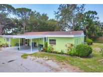 Bright home featuring a carport and lush landscaping around the perimeter of the house at 3500 Green View Ct # 45, Sarasota, FL 34231