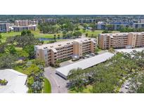 Aerial view of the condo building with golf course views, mature trees, and covered parking at 3750 Pinebrook Cir # 405, Bradenton, FL 34209