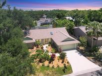 An aerial perspective of a well maintained home surrounded by lush greenery and mature trees at 4079 Woodview Dr, Sarasota, FL 34232