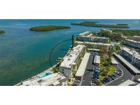 Stunning aerial view of waterfront condo complex with boat docks and beautiful surrounding nature at 4420 Exeter Dr # L104, Longboat Key, FL 34228