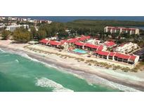 Beautiful aerial view of beachfront condos with red roofs and sparkling blue pool near the ocean at 4621 Gulf Of Mexico Dr # 2F, Longboat Key, FL 34228