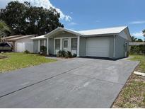 Charming single-story home with a well-maintained lawn and a paved driveway leading to an attached garage at 4833 Dogwood St, New Port Richey, FL 34653