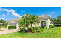 Inviting single-story home featuring a lush lawn, verdant plantings, and attractive neutral-toned exterior paint at 5450 Fairfield Blvd, Bradenton, FL 34203