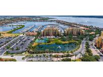 Stunning aerial view of a waterfront condo building with a marina, lake, and tennis courts at 606 Riviera Dunes Way # 306, Palmetto, FL 34221