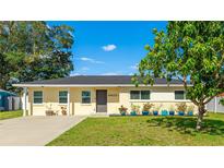 Charming single-story home featuring a well-maintained lawn and tidy landscaping with beautiful blue planters at 6423 Georgia Ave, Bradenton, FL 34207