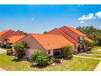 Beautiful home featuring lush landscaping, an orange roof and inviting front porch at 6462 Draw Ln # 72, Sarasota, FL 34238
