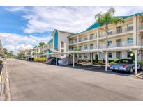 Exterior view of the condo units with parking spots underneath and landscaped grounds at 7301 29Th Avenue W Dr # 108, Bradenton, FL 34209