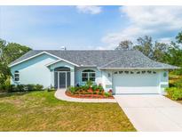 Charming single-story home features a well-manicured lawn, a two-car garage, and colorful landscaping at 10001 289Th E St, Myakka City, FL 34251