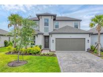 Two-story home with a well-manicured lawn and a two-car garage at 1017 Fernleaf Run, Bradenton, FL 34212