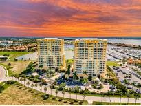 Luxury waterfront condo complex with vibrant landscaping, marina, and beautiful sunset views at 130 Riviera Dunes Way # 304, Palmetto, FL 34221