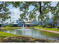 Scenic view of property overlooking a pond with fountain and surrounded by well-maintained landscaping at 1311 Siesta Bayside Dr # 1311-A, Sarasota, FL 34242