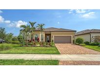 Beautiful single-story home featuring a lush landscaped yard, paver driveway, and well-maintained exterior at 17905 Waterville Pl, Bradenton, FL 34202
