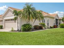 Charming single-story home featuring a well-manicured lawn, mature palm trees, and neutral-colored stucco at 1831 San Silvestro Dr, Venice, FL 34285